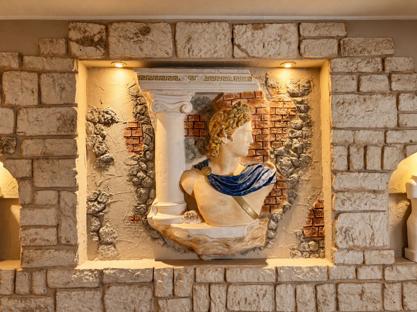 Wandrelief in der Taverne: Säule und griechische Büste in einer Steinnische